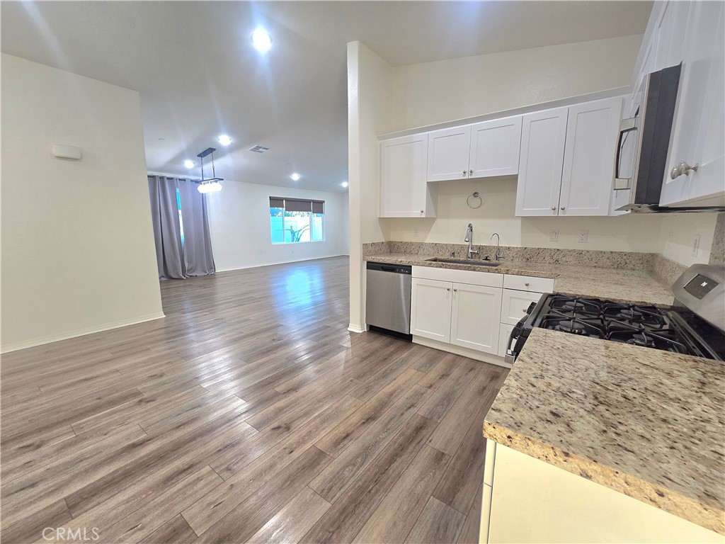 6451 Canyonlands Drive Jurupa Valley, CA 92509 - Photo 3 of 23 a kitchen with a stove a sink and a refrigerator
