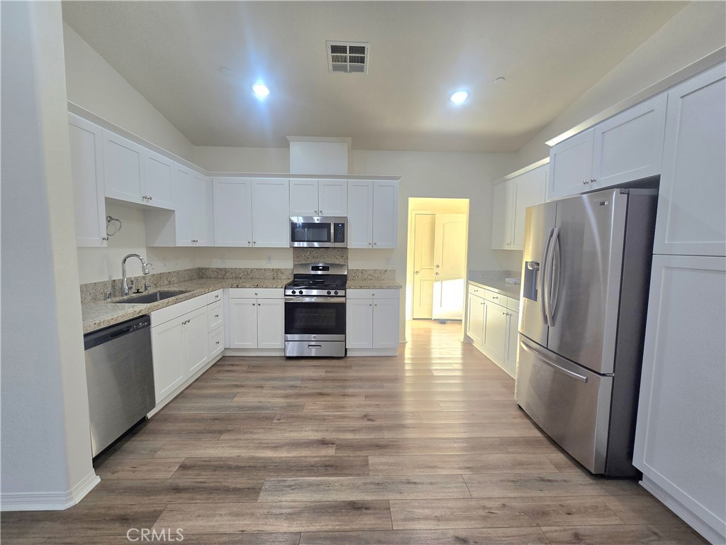 6451 Canyonlands Drive Jurupa Valley, CA 92509 - Photo 4 of 23 a large kitchen with a refrigerator and a sink