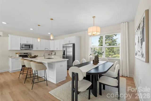 a kitchen with stainless steel appliances kitchen island granite countertop a kitchen island a stove a table and chairs in it