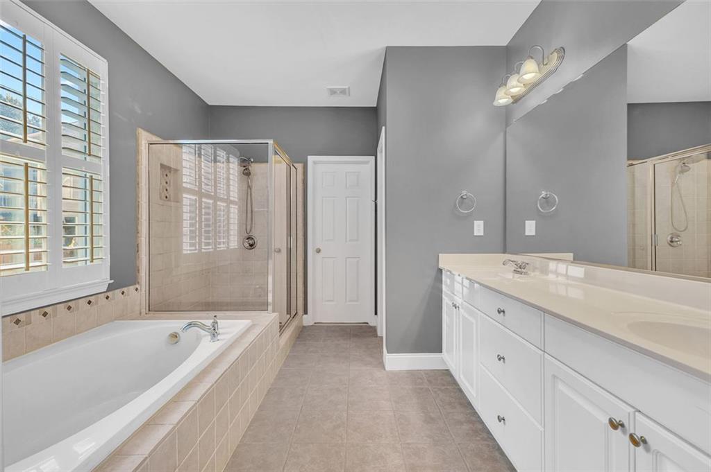 2403 Bonshaw Lane Southwest Marietta, GA 30064 - Photo 27 of 47 a spacious bathroom with a granite countertop tub a double vanity sink and a large mirror