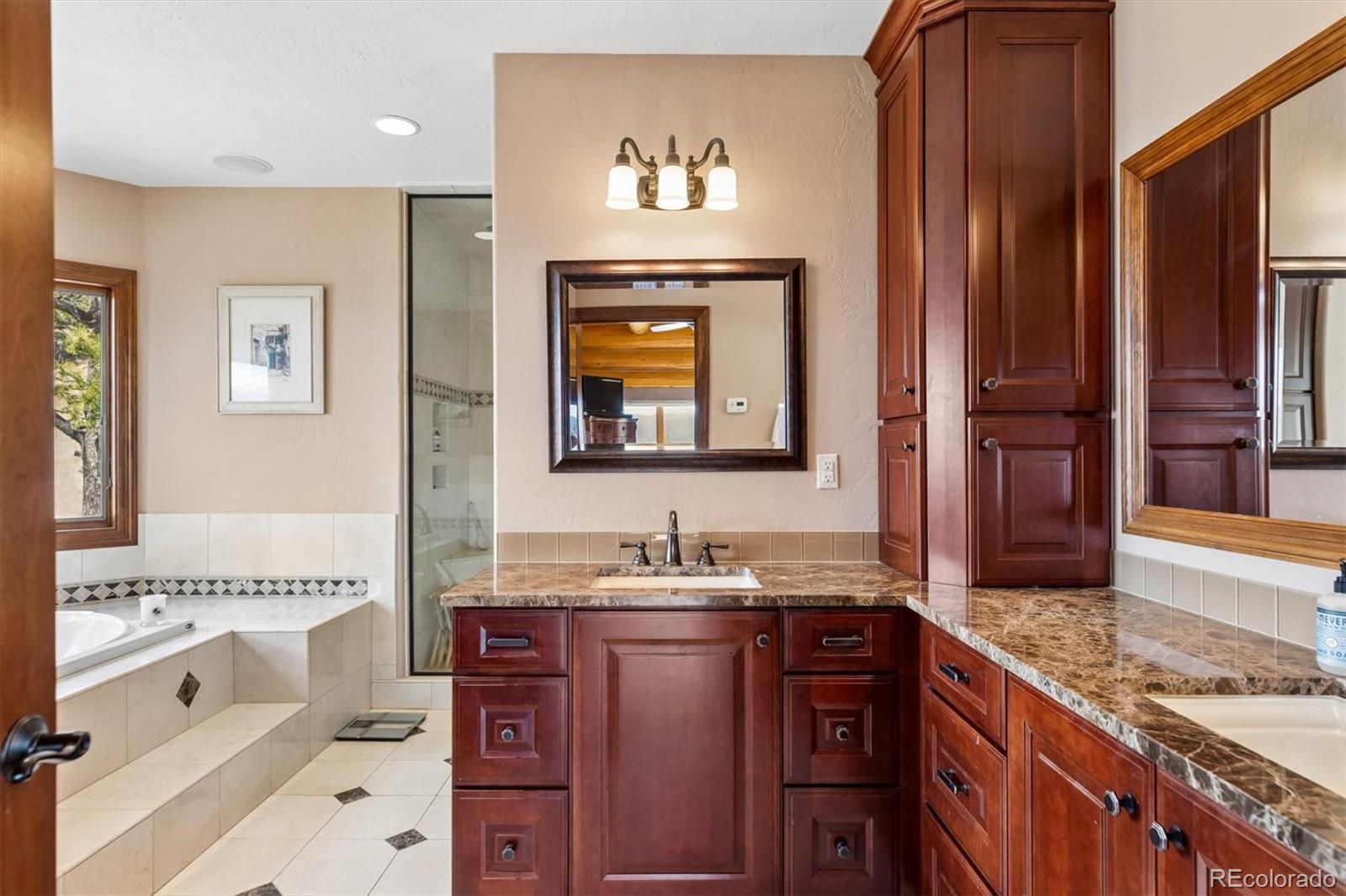 401 Raptor Point Golden, CO 80403 - Photo 27 of 48 a bathroom with a granite countertop tub sink and mirror