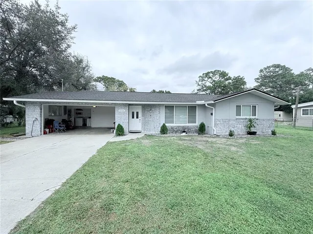 a front view of house with a garden and trees