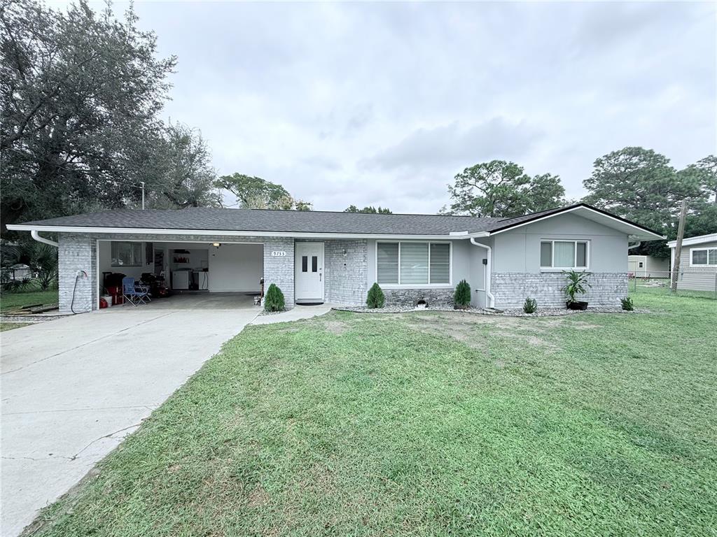 a front view of house with a garden and trees