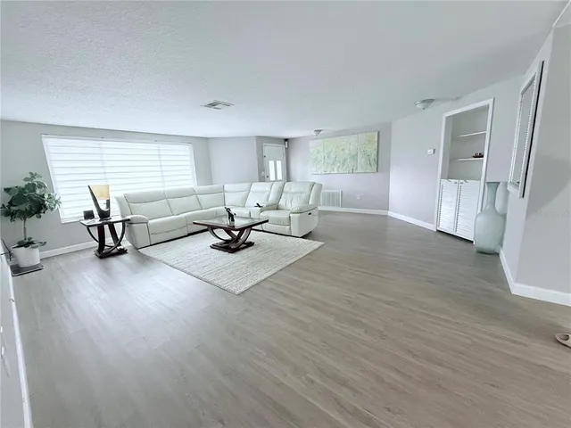 a view of a livingroom with furniture wooden floor and windows