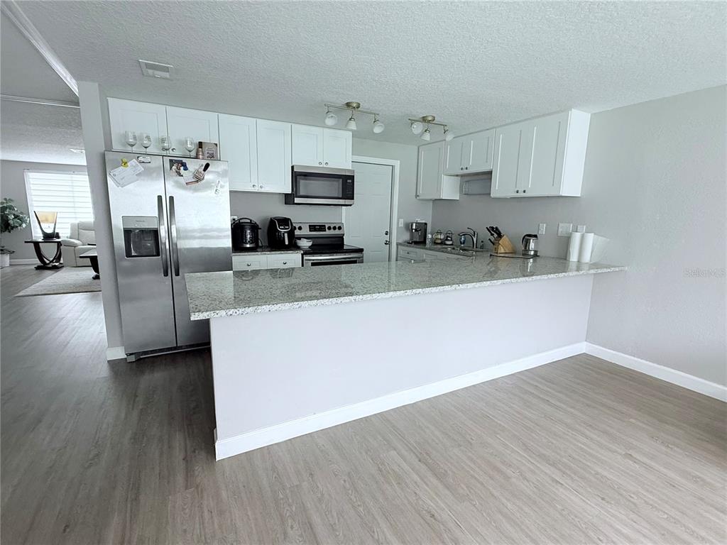 9733 Dick Street Hudson, FL 34669 - Photo 36 of 40 a kitchen with stainless steel appliances a sink a stove a refrigerator and cabinets