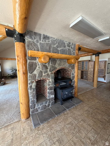 4458 East Glencoe Road Preston, ID 83263 - Photo 4 of 46 Stone fireplace with a brick firebox and a substantial wood mantel, featuring a wood-burning stove on a stone hearth