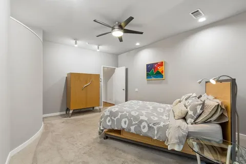 a bedroom with a bed and a ceiling fan