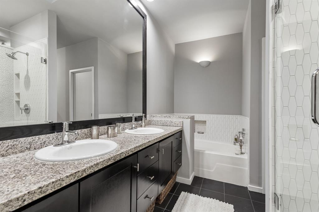 4139 Travis Street Dallas, TX 75204 - Photo 15 of 26 a bathroom with a granite countertop sink and a mirror