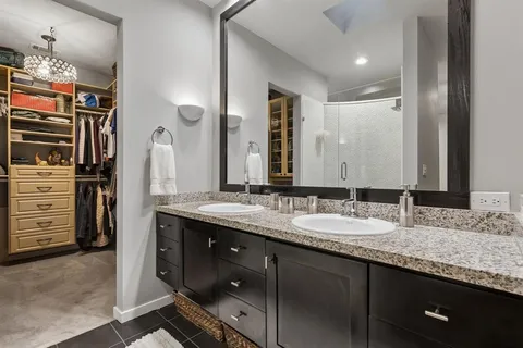 a bathroom with a granite countertop sink double vanity and a mirror
