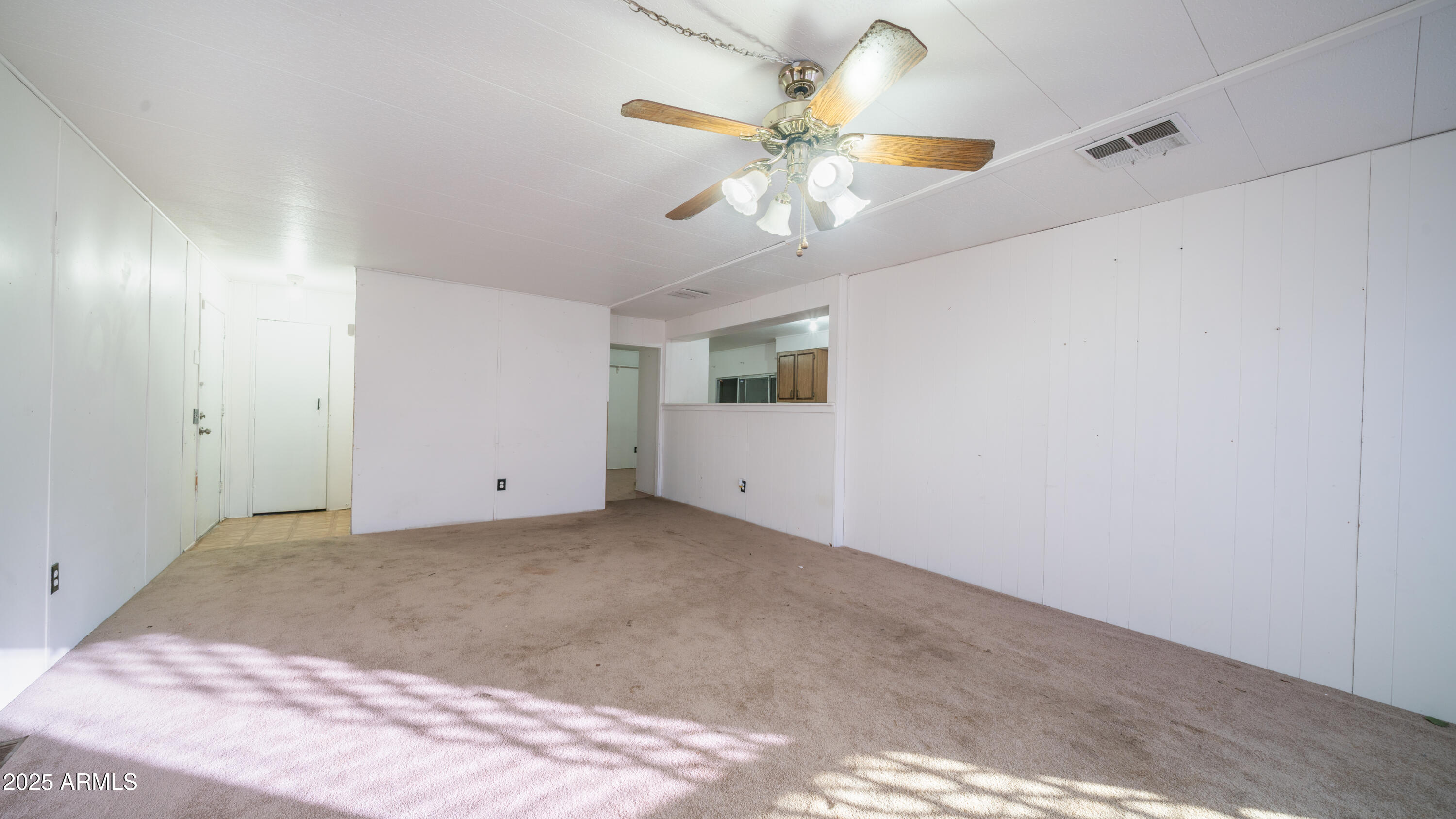 2359 South Tomahawk Road Apache Junction, AZ 85119 - Photo 6 of 32 an empty room with a chandelier fan and windows