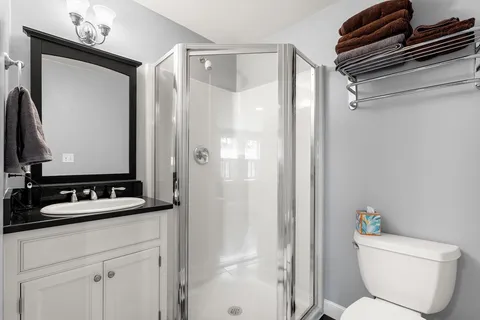a bathroom with a granite countertop sink toilet and shower