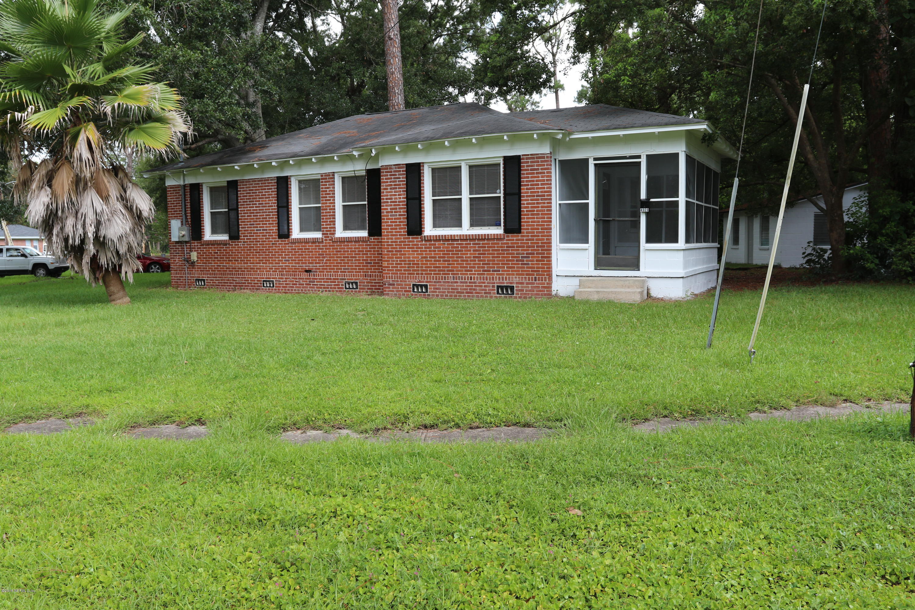 4909 Dundee Road Jacksonville, FL 32210 - Photo 1 of 18 a backyard of a house with table and chairs