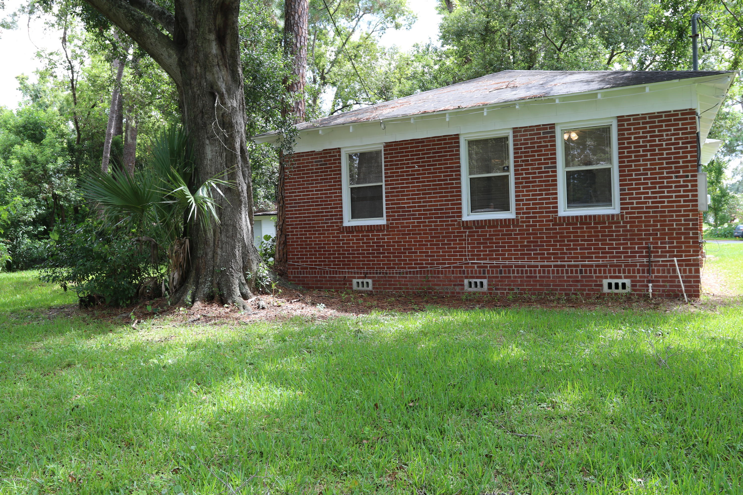 4909 Dundee Road Jacksonville, FL 32210 - Photo 5 of 18 a brick house with a yard