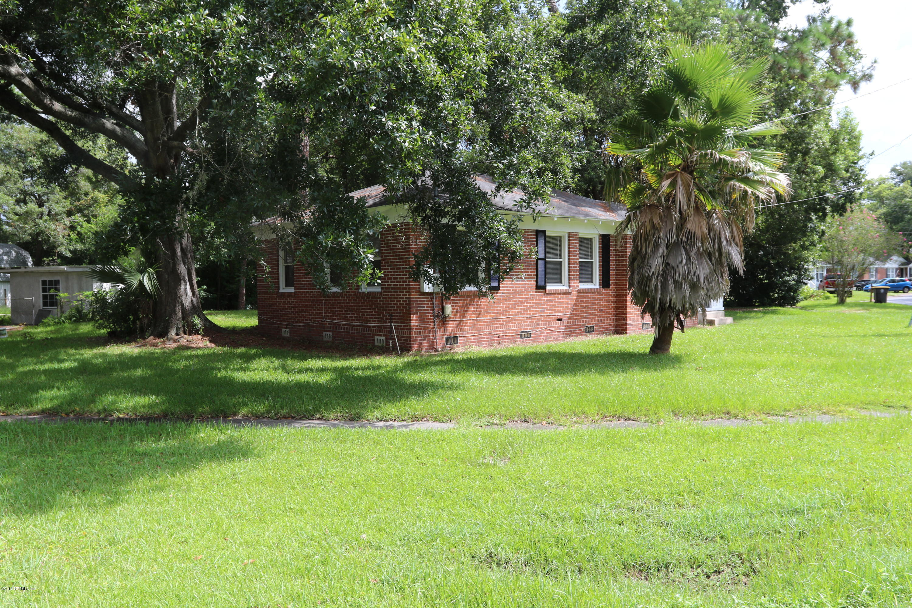 4909 Dundee Road Jacksonville, FL 32210 - Photo 6 of 18 a view of a backyard with table and chairs and a large tree