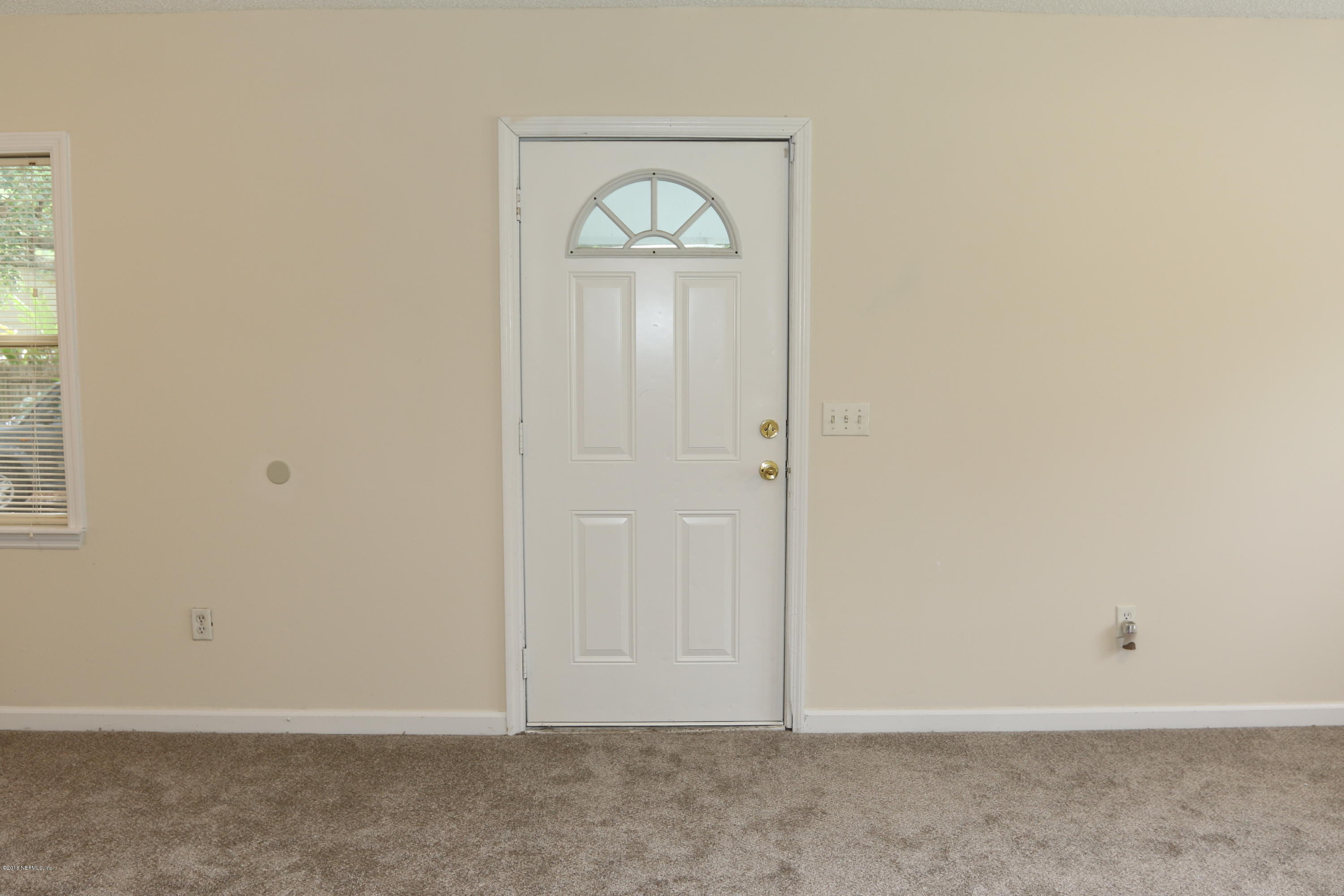 4909 Dundee Road Jacksonville, FL 32210 - Photo 9 of 18 an empty room with wooden floor and a window