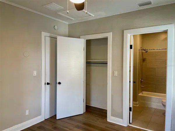 a view of a room with wooden floor closet and windows