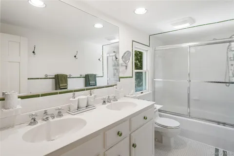 a bathroom with a double vanity sink toilet and shower