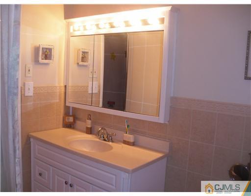 38 Wilk Road Edison, NJ 08837 - Photo 13 of 25 a bathroom with a granite countertop sink and a mirror