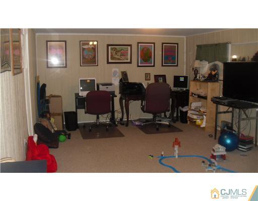 38 Wilk Road Edison, NJ 08837 - Photo 20 of 25 a living room with furniture gym equipment and a flat screen tv