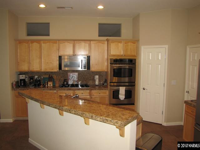 5547 New Mexico Court Reno, NV 89511 - Photo 3 of 12 a kitchen with stainless steel appliances granite countertop a stove a sink and a refrigerator