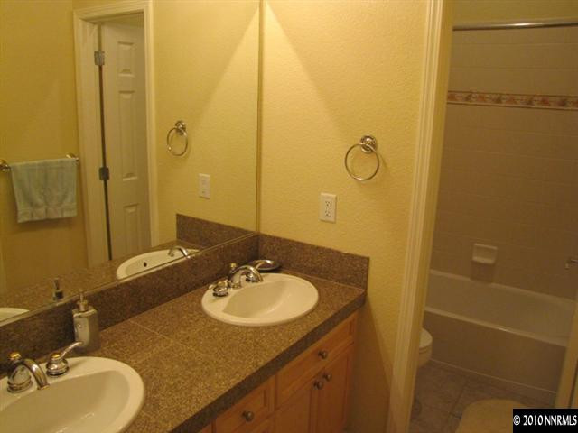 5547 New Mexico Court Reno, NV 89511 - Photo 7 of 12 a bathroom with a granite countertop sink and a mirror