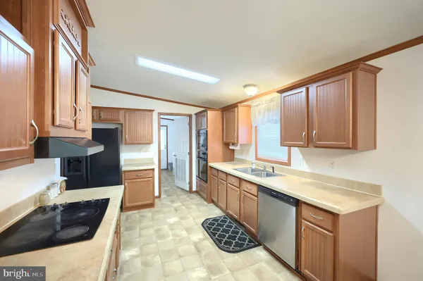 a kitchen with stainless steel appliances granite countertop a white table chairs and a refrigerator
