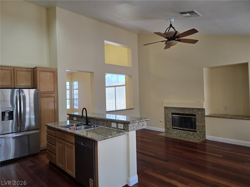 8417 San Ramon Drive Las Vegas, NV 89147 - Photo 10 of 33 An inviting open-concept area combines the kitchen, dining, and living spaces, centered around a cozy fireplace.