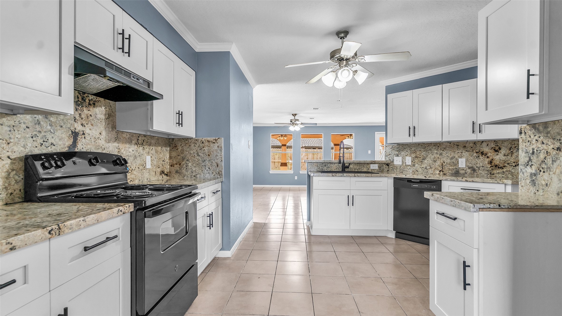 5534 Calm Court Houston, TX 77084 - Photo 6 of 44 a kitchen with a stove top oven a sink a counter top space and cabinets