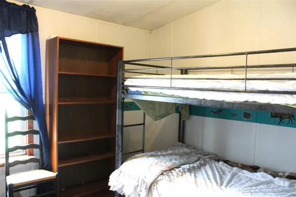 a bed sitting in a bedroom next to a window