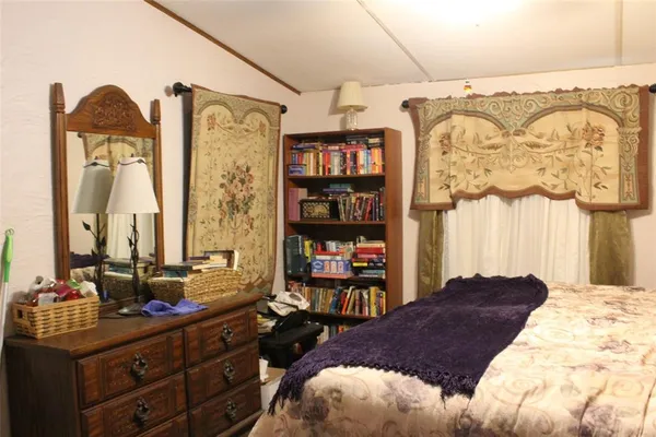 a bedroom with a bed dresser and a window