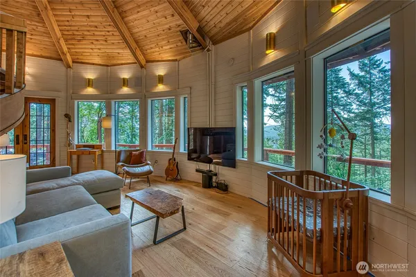 a living room with furniture tv and large windows