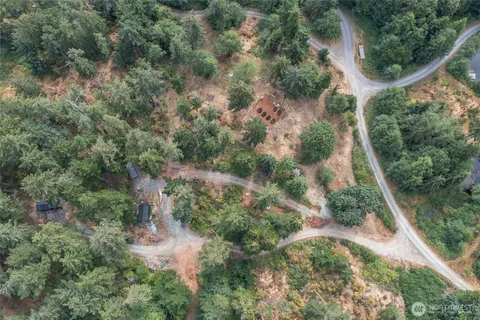 an aerial view of residential house with outdoor space and trees all around