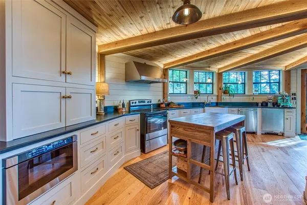 a kitchen with stainless steel appliances granite countertop a stove a sink and cabinets