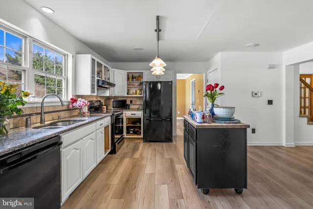a kitchen with granite countertop a stove a sink dishwasher and a refrigerator