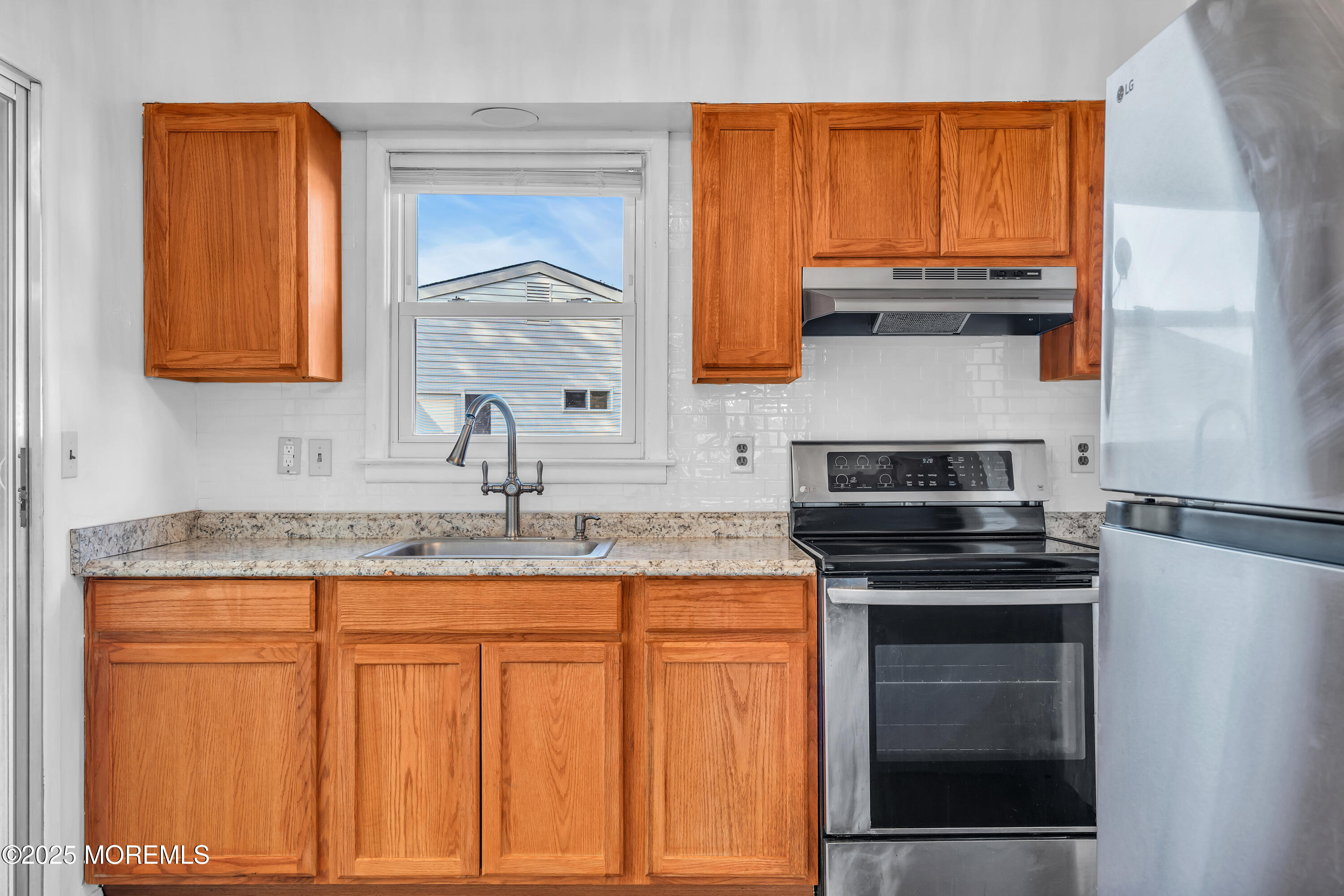 11 Hartford Road, Unit 70 Whiting, NJ 08759 - Photo 19 of 32 a kitchen with granite countertop a sink stove and cabinets
