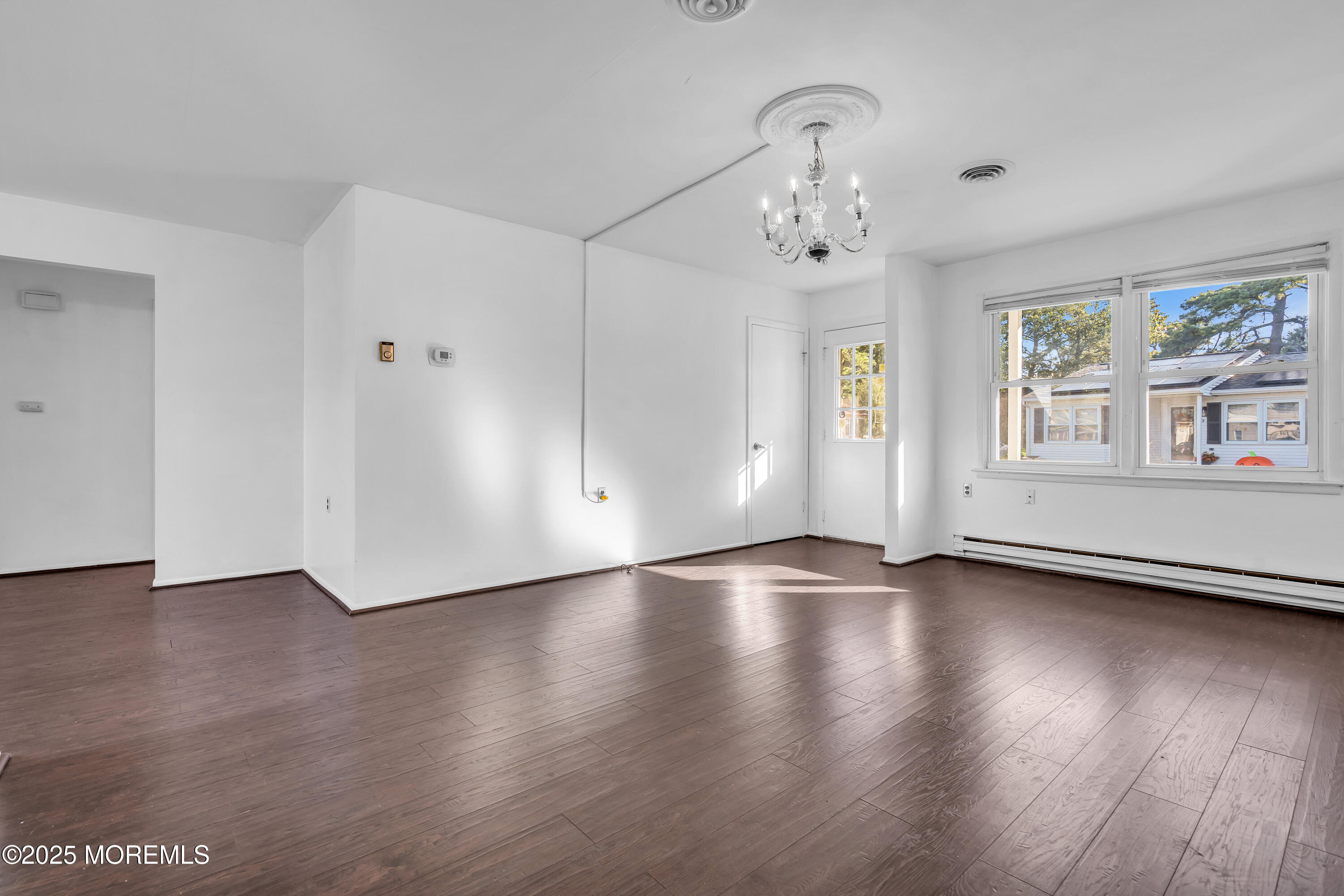 11 Hartford Road, Unit 70 Whiting, NJ 08759 - Photo 2 of 32 an empty room with wooden floor chandelier and windows