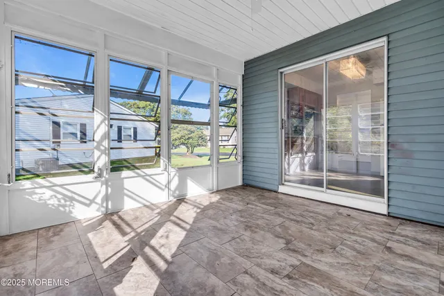 a view of empty room with floor to ceiling window and outdoor kitchen