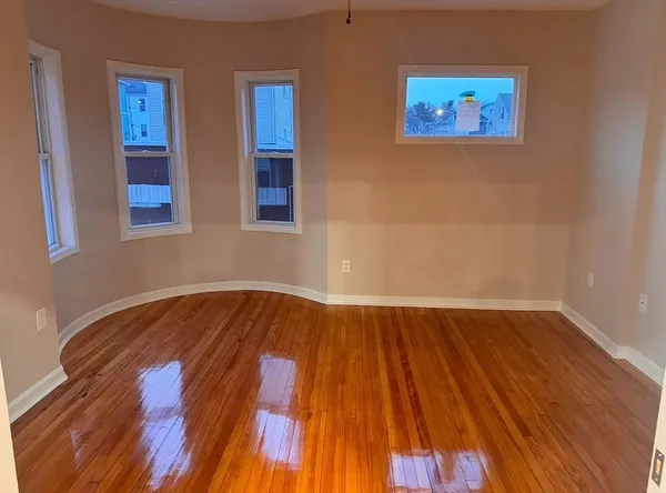 a view of a room with wooden floor and window