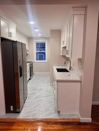 a kitchen with a refrigerator sink and cabinets