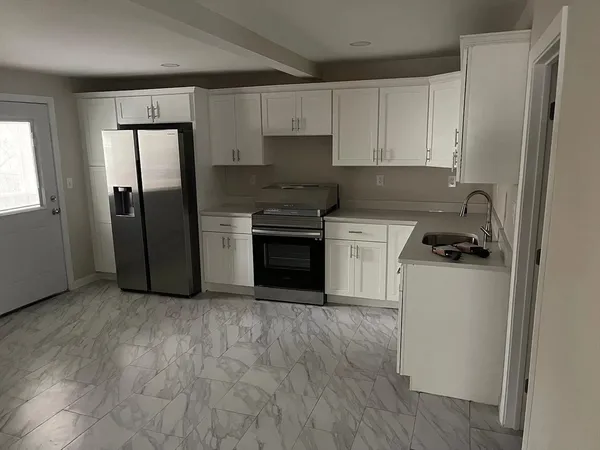 a kitchen with a refrigerator and a stove top oven