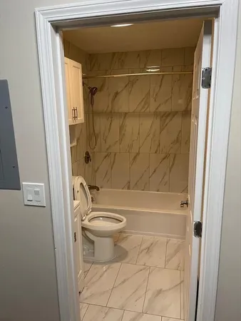 a bathroom with a shower a toilet and a sink