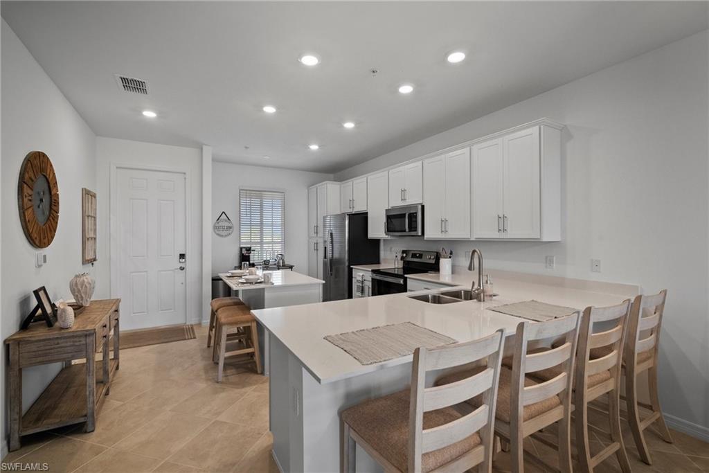 43985 Boardwalk Loop, Unit 2143 Babcock Ranch, FL 33982 - Photo 11 of 25 a kitchen that has a table and chairs in it