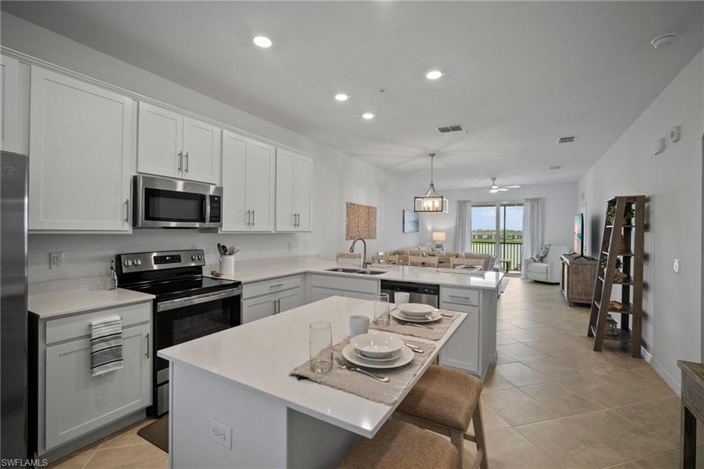 43985 Boardwalk Loop, Unit 2143 Babcock Ranch, FL 33982 - Photo 12 of 25 a kitchen with a stove a sink and a refrigerator