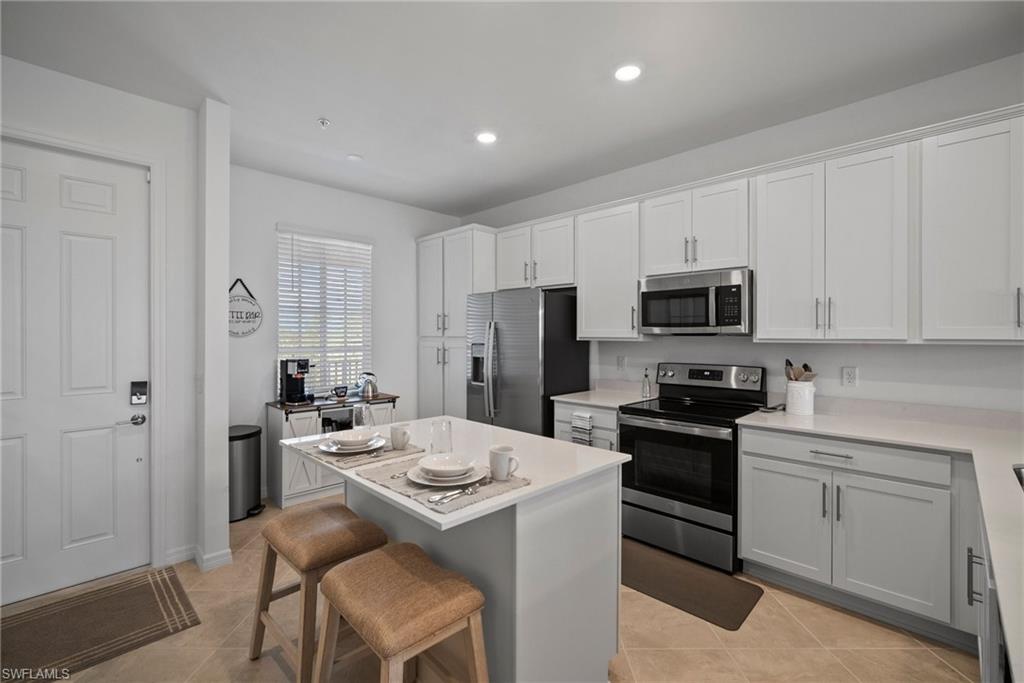 43985 Boardwalk Loop, Unit 2143 Babcock Ranch, FL 33982 - Photo 13 of 25 a kitchen with a sink a stove a refrigerator and white cabinets