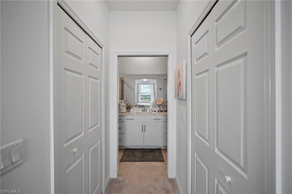43985 Boardwalk Loop, Unit 2143 Babcock Ranch, FL 33982 - Photo 18 of 25 a en suite bathroom with a sink mirror and a shower