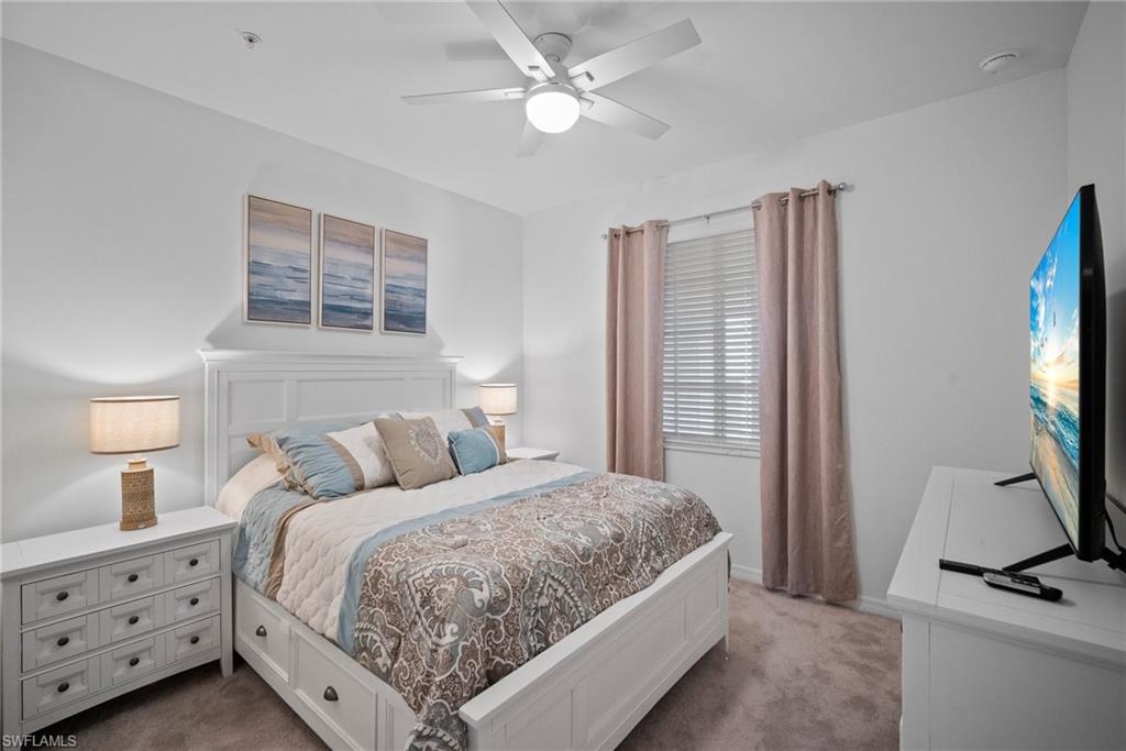 43985 Boardwalk Loop, Unit 2143 Babcock Ranch, FL 33982 - Photo 21 of 25 a bedroom with a bed and a flat tv screen on dresser