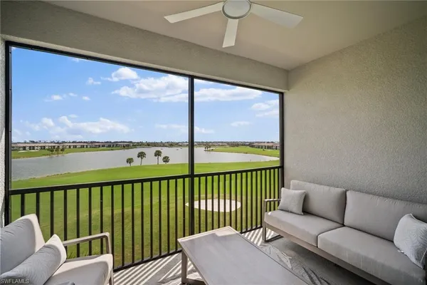 a living room with furniture floor to ceiling window and an outdoor view