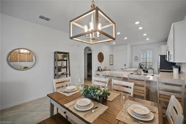 a living room with furniture a chandelier and a table