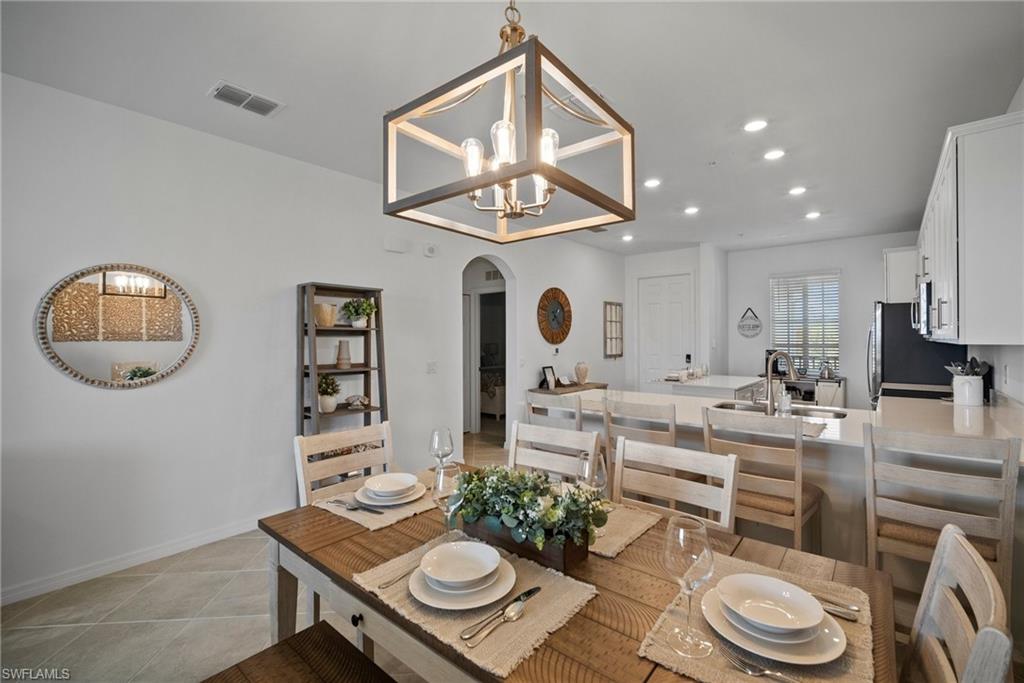 43985 Boardwalk Loop, Unit 2143 Babcock Ranch, FL 33982 - Photo 9 of 25 a living room with furniture a chandelier and a table