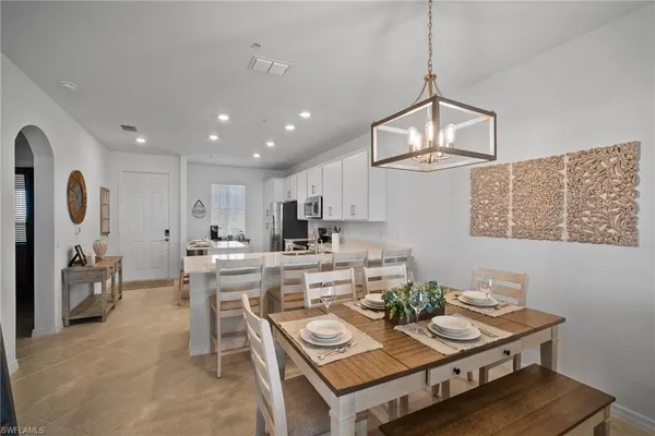 a view of a dining room with furniture a rug and wooden floor